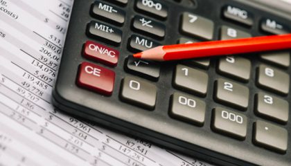calculadora financeira com um lápis vermelho em cima
