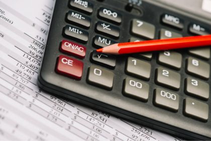 calculadora financeira com um lápis vermelho em cima